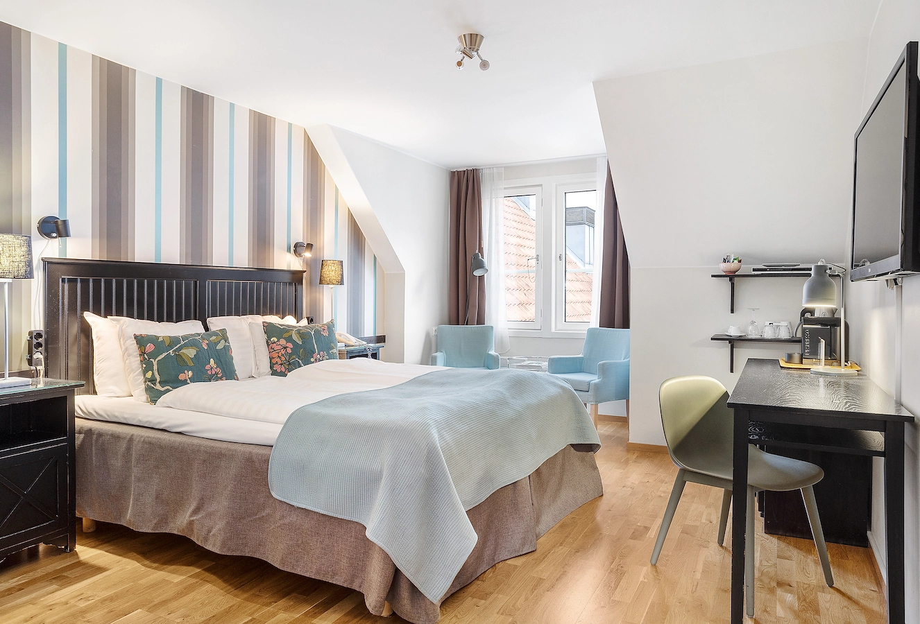 Säng i deluxerum på Hotel Noble House