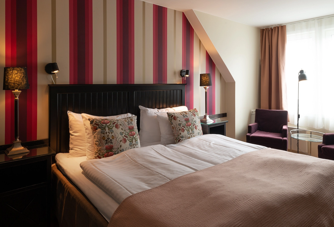 Säng i deluxerum på Hotel Noble House